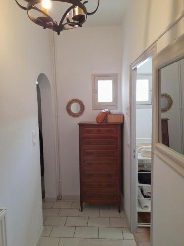 a bathroom with a wooden dresser and a mirror at La maison de Toinette in Arles