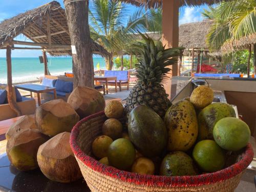 a basket of fruit on a table near a beach at Summer Beach Paje in Paje