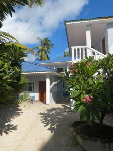 a white house with trees in front of it at Summer Beach Paje in Paje