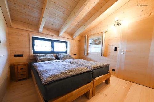 ein Bett in einem kleinen Zimmer in einem winzigen Haus in der Unterkunft Holzwies Chalets in Unterneukirchen