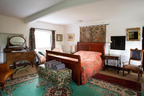 a bedroom with a bed and a chair and a mirror at Johnby Hall in Penrith