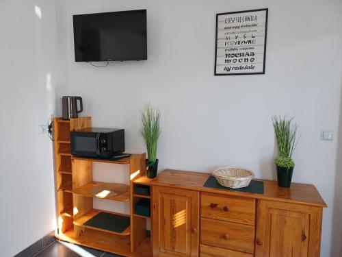 a room with a wooden cabinet with a tv on a wall at U Siuhajów in Frydman