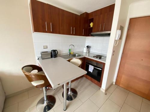 a small kitchen with a white table and chairs at Edificio Trizano depto 2 Ambientes con Balcón y Estacionamiento in Temuco