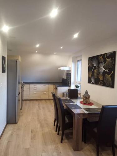 une cuisine et une salle à manger avec une table et des chaises dans l'établissement Chez Sandra, à Dalhunden