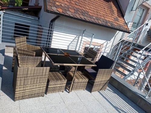 a picnic table with wicker chairs on a patio at Chez Sandra in Dalhunden