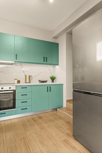 a kitchen with blue cabinets and a stainless steel refrigerator at Elia Suite in Riglia