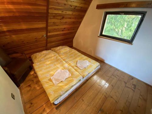an empty bed in a room with a window at Chata pod Černou horou in Rudník