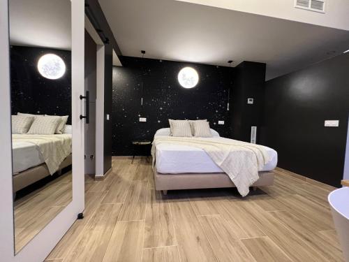 two beds in a room with black walls and wooden floors at Casal de pelaio in Barreiros
