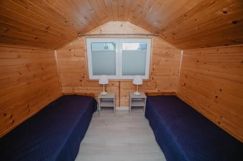 pokój z 2 łóżkami w drewnianym pokoju w obiekcie DOMEK MIEDZY MORZAMI w Kuźnicy