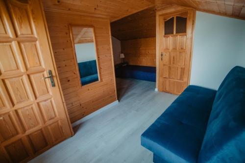 a living room with a blue couch and a door at DOMEK MIEDZY MORZAMI in Kuźnica