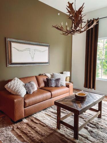 a living room with a brown couch and a table at Cozy Cabin - 2 Miles to Broadway & Free Parking in Nashville