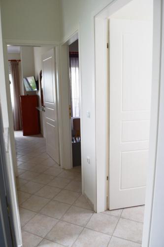 a hallway with white doors and a tile floor at Aegean Dreams Villa Palio in Paleo Tsifliki