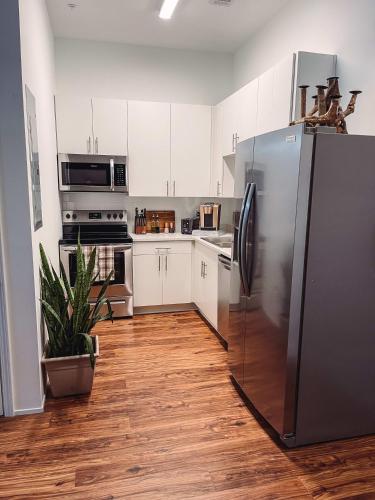 a kitchen with white cabinets and a stainless steel refrigerator at Cozy Cabin - 2 Miles to Broadway & Free Parking in Nashville