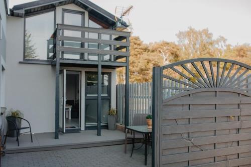 a patio with a fence and a table and a chair at DOMEK MIEDZY MORZAMI in Kuźnica