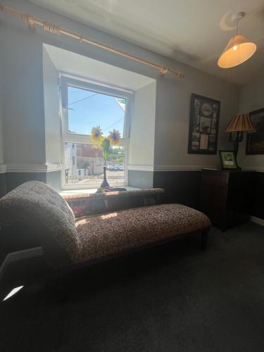 a living room with a couch and a window at Annie May's Bar, B&B in Skibbereen