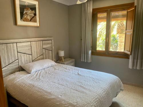 a bedroom with a white bed and a window at Charming Home in Lorca Murcia in Lorca