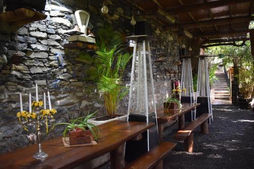a group of wooden benches with plants on a stone wall at ROMANTICA in San Bartolomé