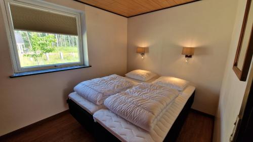 uma cama num quarto com uma janela em Hummingenstrand38 em Dannemare