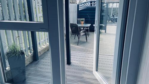 a view from a glass door of a balcony with a table at DOMEK MIEDZY MORZAMI in Kuźnica