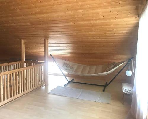 a hammock in a room with a wooden wall at Villa Keyritty - Near Tahko Ski/Holiday Resort in Kuopio