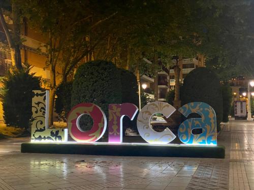a sign that says open on a sidewalk at night at Charming Home in Lorca Murcia in Lorca