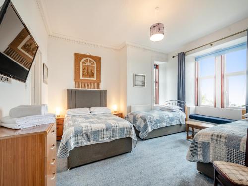 1 dormitorio con 2 camas y TV de pantalla plana en Braefield en Portpatrick