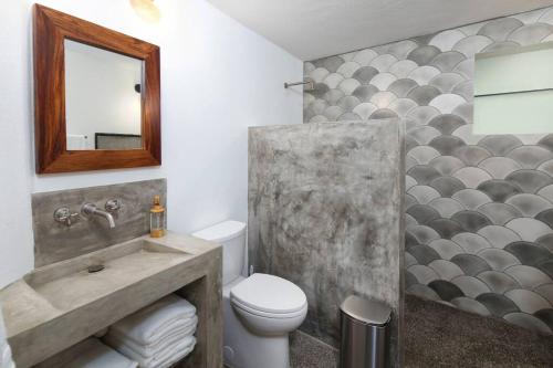 a bathroom with a toilet and a mirror at Villa Robalo - Duplex in Sayulita