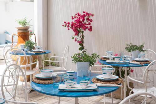 un tavolo con tavoli e sedie blu con fiori di IL CORTILETTO a Porto Cesareo