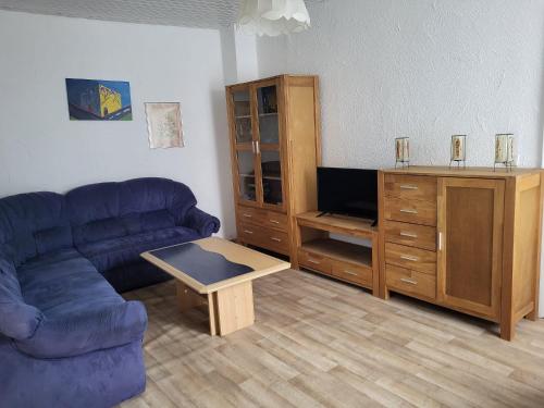 a living room with a couch and a tv at Ferienwohnung-Kiefer in Hillscheid