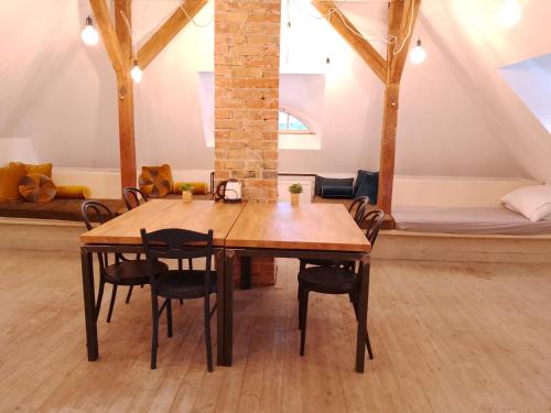 a wooden table and chairs in a room with a bed at Apartamenty Pod Sosnami in Sopot