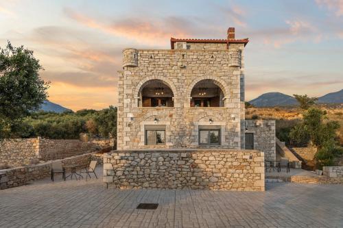 un edificio de piedra con mesas y sillas en un patio en Petra Suite, en Riglia