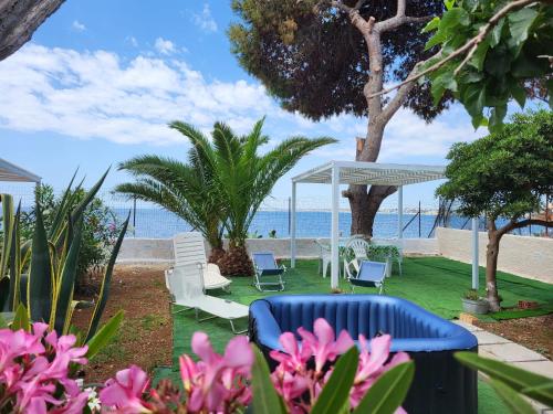 ogród z krzesłami, altaną i plażą w obiekcie La Caletta di Afrodite w mieście Calabernardo