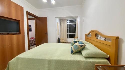 ein Schlafzimmer mit einem Bett und einem TV darauf in der Unterkunft Luxuoso a 250 Mts da Praia in Guarapari