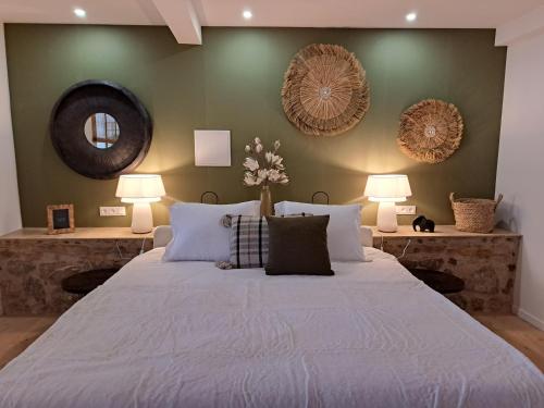 a bedroom with a large white bed with two lamps at Hôtel Le Cottage de Sophie in Valernes