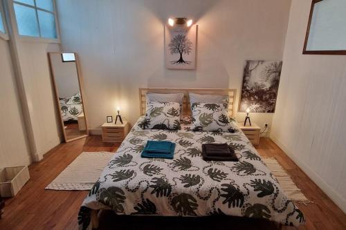 1 dormitorio con 1 cama con manta y almohadas en Appartement dans Maison de ville - 4 personnes, en Oloron-Sainte-Marie