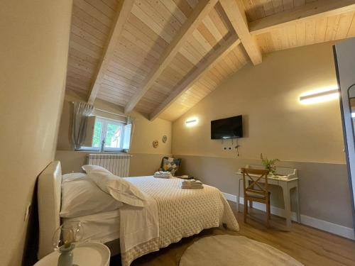 1 dormitorio con cama, mesa y TV en B&B Ai Cortili en Sant'Egidio del Monte Albino