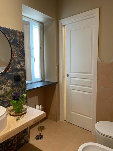 a bathroom with a toilet and a sink and a mirror at B&B Ai Cortili in Sant'Egidio del Monte Albino
