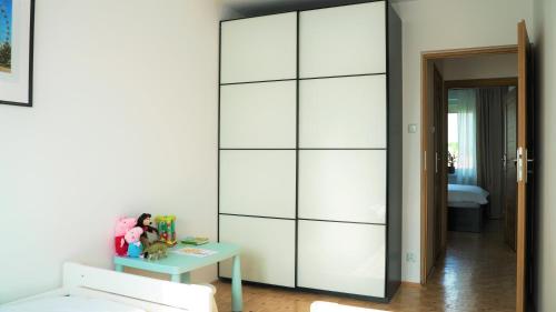 a large white wardrobe in a room with a table at Apartament ENJOY Zator - z widokiem na Energylandie in Zator