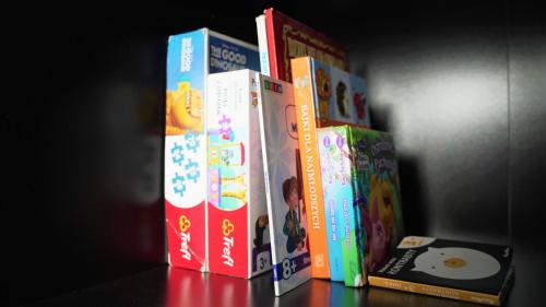 a group of childrens books stacked on a shelf at Apartament ENJOY Zator - z widokiem na Energylandie in Zator