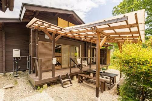 a small house with a pergola and a patio at ウッドペッカー小径 in Nasu