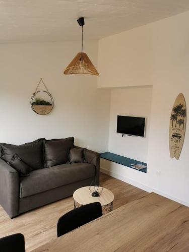un salon avec un canapé et une table dans l'établissement L îlot du Courseau, au Bois-Plage-en-Ré