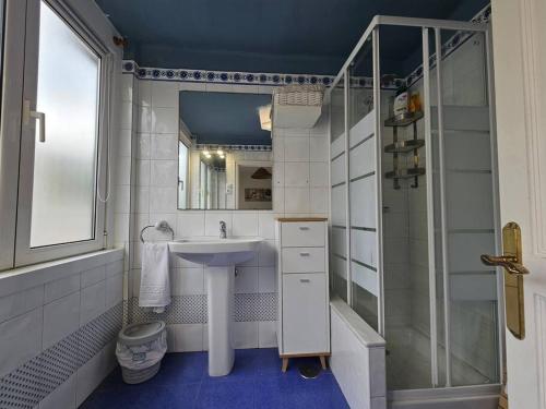 een witte badkamer met een wastafel en een douche bij 13A02 Céntrico 4 dormitorios in Ribadesella