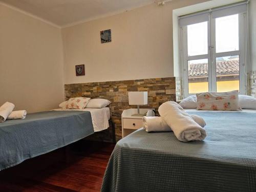 een slaapkamer met 2 bedden en een raam bij 13A02 Céntrico 4 dormitorios in Ribadesella