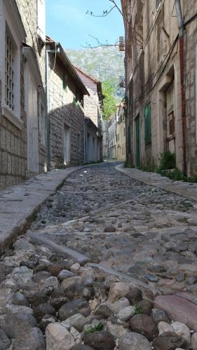 an empty cobblestone street in an alley with buildings at Old Risan Apartment in Risan