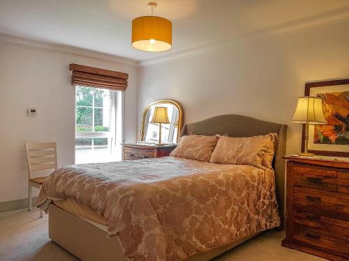 a bedroom with a bed and a table and a mirror at Torrance At Abbey Park Avenue in St. Andrews