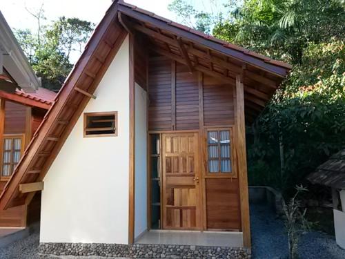 uma pequena casa com uma grande porta de madeira em Pousada Chalés do Atlântico Sc em Itapoa