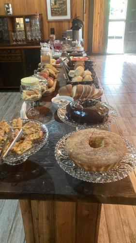 a table with many different types of food on it at Pousada Querência Tarumã in São Joaquim
