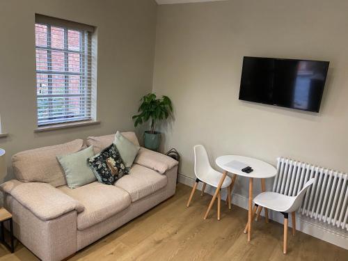 a living room with a couch and a table at Cosy small cottage in Wirral Merseyside with kitchen in Lower Bebington