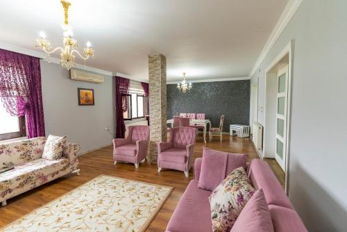 ein Wohnzimmer mit rosa Möbeln und ein Esszimmer in der Unterkunft Villa Fatma in Trabzon
