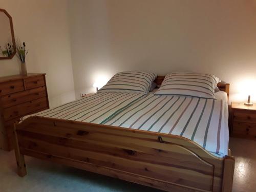 - une chambre avec un lit en bois et 2 oreillers dans l'établissement Ferienwohnung Hans, à Lindenfels